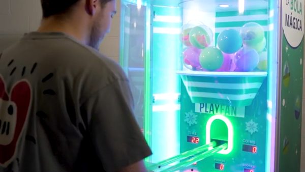Joven jugando a la áquina recretaiva de bolas con premios de play fan